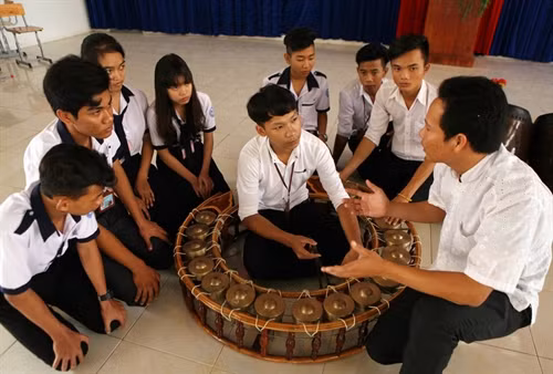 Thầy giáo Lâm Thanh Nhã, dân tộc Khmer, cựu học sinh của trường dạy học sinh cách sử dụng nhạc cụ đặc trưng của đồng bào dân tộc Khmer.