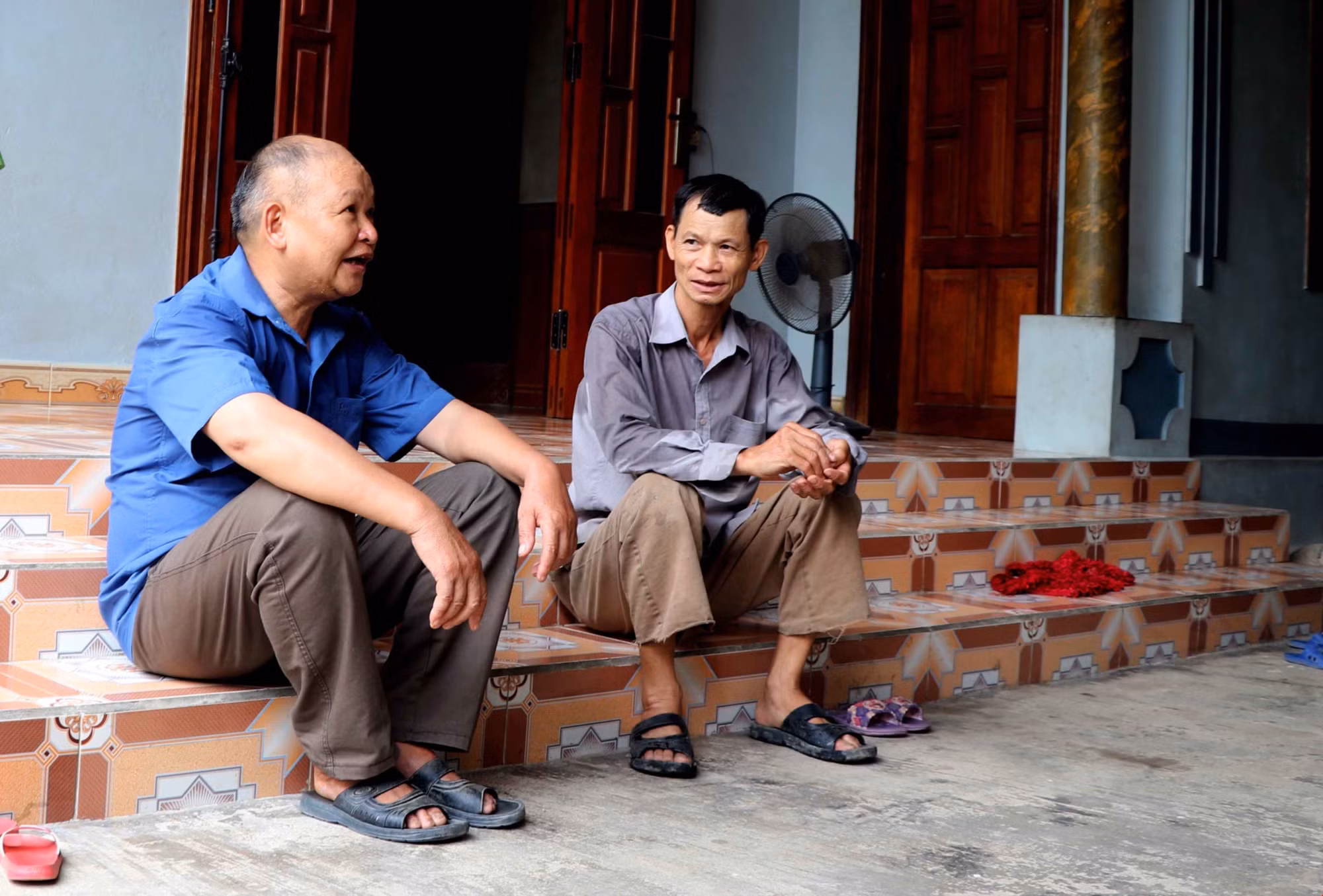 Ông Lý Văn Dau (bên trái) vận động người dân thực hiện tốt đường lối chủ trương của Đảng, pháp luật của Nhà nước. Ảnh: Quang Cường – TTXVN