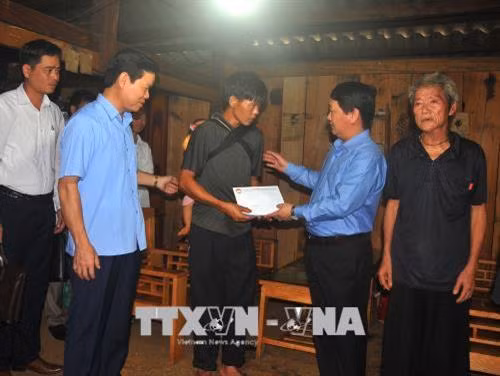 Phó Chủ tịch, Tổng Thư ký Ủy ban Trung ương Mặt trận Tổ quốc Việt Nam Hầu A Lềnh trao tiền hỗ trợ cho gia đình bị thiệt hại nặng nề do mưa lũ ở thôn Tùng Nùn, xã Lùng Tám, huyện Quản Bạ. Ảnh: Minh Tâm - TTXVN