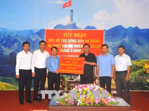 Phó Chủ tịch, Tổng Thư ký Ủy ban Trung ương Mặt trận Tổ quốc Việt Nam Hầu A Lềnh trao bảng tượng trưng một tỷ đồng của Ban cứu trợ Trung ương hỗ trợ đồng bào Hà Giang bị thiệt hại do mưa lũ. Ảnh: Minh Tâm - TTXVN