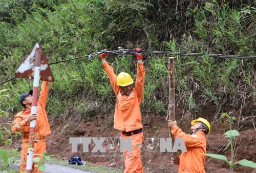 Cán bộ nhân viên kỹ thuật của công ty điện Nậm Nhùn (Mường Tè) kiểm tra, khắc phục sự cố hệ thống lưới điện bị thiệt hại do mưa lũ gây ra tại bản Gia Tè, xã Mù Cả. Ảnh: Quý Trung - TTXVN