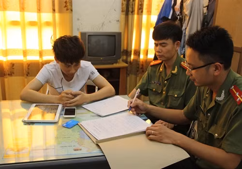 Đối tượng Bùi Đức Hải (áo trắng) bị triệu tập tại cơ quan Công an tỉnh Thái Bình. Ảnh: Xuân Tiến-TTXVN