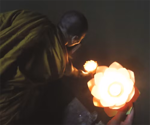 Nhà sư thắp nén nhang lên đèn nước của nhà chùa Nhà sư là người thả đèn nước đầu tiên