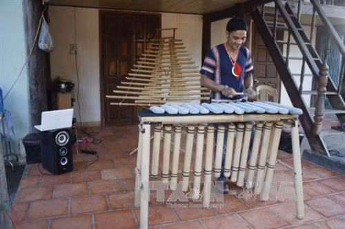 Kaly Tran biễu diễn một bản nhạc Tây Nguyên với bộ đàn đá do chính tay anh chế tác. Ảnh: Hồng Điệp - TTXVN