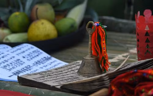 Bàn thờ treo bộ tranh thờ “Tam thanh” - 3 vị thần trong tín ngưỡng người Dao cai quản 3 nơi là Ngọc thanh (thần cai quản trên trời), Thượng thanh (thần cai quản trần gian) và Thái thanh (thần cai quản âm phủ). Theo truyền thuyết, tuy là vua nhưng Bàn Vương vẫn giữ thói quen sống giản dị, gần gũi với thiên nhiên. Ngài luôn căn dặn các con phải chăm chỉ lao động sản xuất. Có một lần, Bàn Vương cùng tùy tùng lên núi săn bắn, đuổi theo một con sơn dương bị thương, chẳng may bị sơn dương húc, ngài ngã vào cây gù hương và mất tại đó. Thi thể Bàn Vương bị vướng trên nhành cây, các con bèn chặt cây làm thân trống, đuổi bắt con sơn dương để lấy da làm trống tế lễ Bàn Vương. Từ đó. cứ đến khoảng tháng 2 Âm lịch hàng năm, con cháu người Dao từ đời này sang đời khác phải nhớ ngày cúng giỗ Bàn Vương, thể hiện sự biết ơn với tổ tiên đã sinh ra họ. Người dân các thôn chuẩn bị lễ vật, chờ đến giờ tốt để dâng lên Bàn Vương. Các thầy cúng bắt đầu thay lễ phục, giúp nhau sửa soạn mũ áo. Chân dung một trong số sáu thầy cúng của buổi lễ. Ông Triệu Chòi Quyên, thầy cúng trong xã, cho biết: "Các thầy cúng sẽ hát những bài ca cúng để nhờ thần linh, thổ địa nghênh đón Bàn Vương xuống đàn, nhận lễ vật của con cháu dâng lên". Sau mỗi lời khấn bằng tiếng Dao, thầy cúng và người dân các thôn cùng quỳ lạy Bàn Vương. Các điệu múa chuông, múa bắt rùa... lần lượt được các thầy cúng thực hiện sau khi mời để tái hiện lại tiểu sử của Bàn Vương năm xưa như vóc dáng, cách hái lượm săn bắn. Việc này theo các thầy cúng vừa để thể hiện ý chí, sức mạnh sinh tồn của người xưa, vừa để nhắc nhở con cháu ngày nay cần cù, chịu khó làm ăn như cha ông trước đây. Theo ông Quyên, vật chày là một trò chơi dân gian thể hiện sức mạnh, sự kết hợp khéo léo, sự bí ẩn của cả người gánh và người vật. Sau khi thầy cúng làm phép nhờ thần linh giúp đỡ, dù rất đông người cùng tham gia nhưng không thể ấn nổi đầu chày chạm đất. Điều này thể hiện việc bản làng năm đó được các vị thần phù hộ, nâng đỡ. Người dân tới dâng lễ và tham gia lễ hội Bàn Vương.