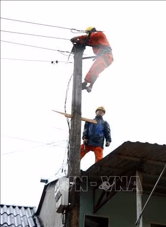 Cán bộ điện lực huyện Bảo Yên khắc phục sự cố mất điện sau mưa lũ. Ảnh: Quốc Khánh – TTXVN