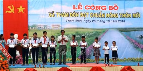 Trao tặng học bổng và sách vở cho học sinh nghèo tại Lễ công nhận xã Tham Đôn đạt chuẩn nông thôn mới. Ảnh: Trung Hiếu - TTXVN