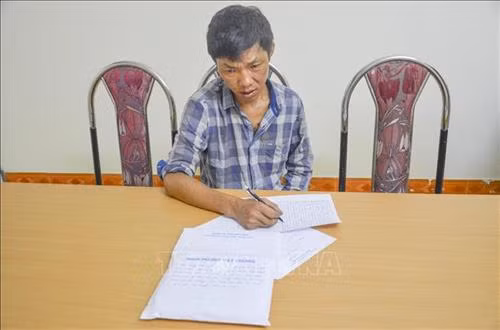 Đối tượng Lầu Thanh Tùng cùng tang vật vụ án tại cơ quan công an. Ảnh: Xuân Tư - TTXVN