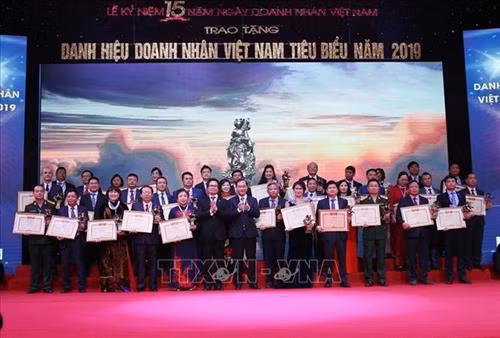 Chủ tịch Phòng Thương mại và Công nghiệp Việt Nam Vũ Tiến Lộc và Chủ nhiệm Ủy ban Kinh tế của Quốc hội Vũ Hồng Thanh trao Bằng chứng nhận của Hội đồng bình xét doanh nhân toàn quốc cho các doanh nhân. Ảnh: Dương Giang - TTXVN