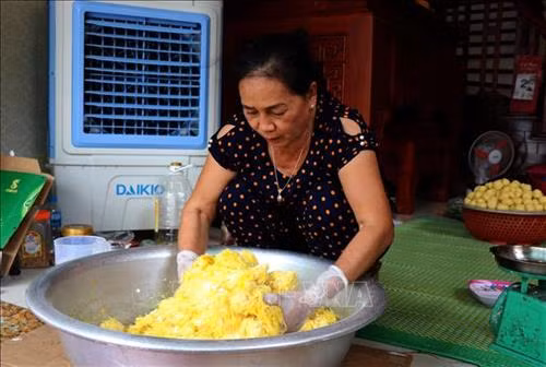 Công đoạn trộn nhân bánh phu thê. Ảnh: Đinh Văn Nhiều-TTXVN