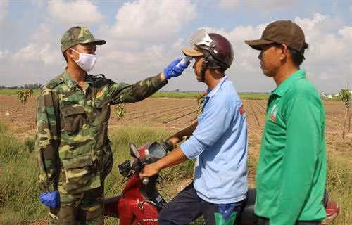 Cán bộ, chiến sĩ phòng, chống dịch COVID-19 số 4 của Đồn Biên phòng quốc tế Vĩnh Xương (Bộ đội Biên phòng tỉnh An Giang) thường xuyên kiểm tra thân nhiệt người dân. Ảnh: Công Mạo