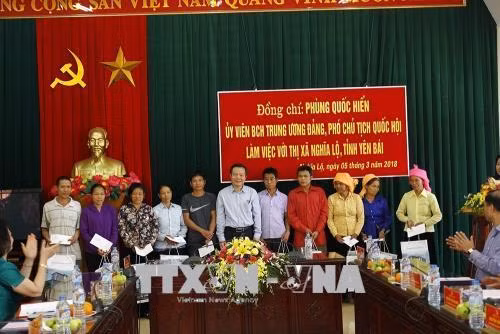 Đồng chí Phùng Quốc Hiển tặng cho các hộ dân bị thiệt hại do bão lũ ở thị xã Nghĩa Lộ. Ảnh: Đỗ Tuấn Anh-TTXVN