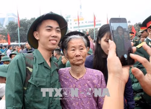 Tân binh Thành phố Vinh (Nghệ An) chia tay người thân trước khi lên đường nhập ngũ. Ảnh: Tá Chuyên - TTXVN