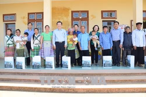 Đồng chí Phùng Quốc Hiển tặng cho các hộ dân bị thiệt hại do bão lũ ở xã Bản Công, huyện Trạm tấu. Ảnh: Đỗ Tuấn Anh-TTXVN
