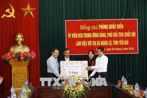 Đồng chí Phùng Quốc Hiển tặng quà cho Đảng bộ, chính quyền thị xã Nghĩa Lộ. Ảnh: Đỗ Tuấn Anh-TTXVN