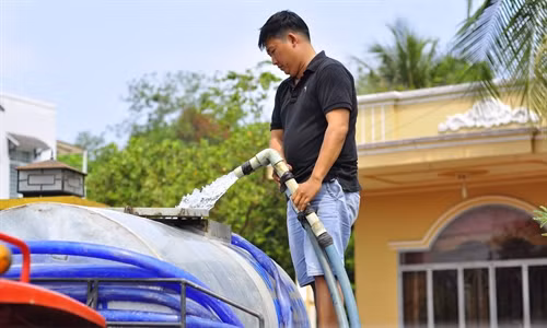 Anh Nguyễn Văn Tuấn (xã Phú Cường) bơm nước vào xe bồn để mang đi bán phục vụ cho người dân trong vùng.