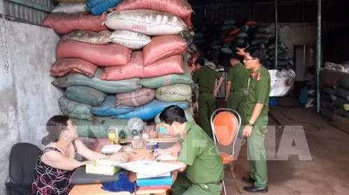 Lực lượng chức năng làm việc với chủ cơ sở sản xuất cà phê bẩn. Ảnh: TTXVN phát