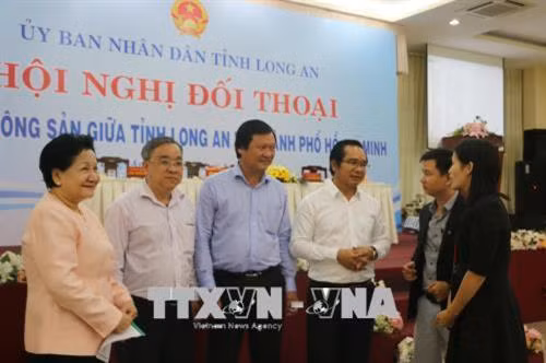 Phó Chủ tịch UBND tỉnh Long An Nguyễn Văn Được trao đổi cùng các doanh nghiệp bên lề Hội nghị. Ảnh: Thanh Bình-TTXVN