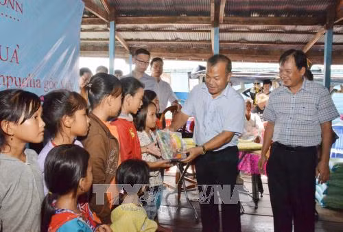 Thứ trưởng Bộ Ngoại giao Vũ Hồng Nam trao quà cho các học sinh nghèo học giỏi. Ảnh: Chanh Đa - Pv TTXVN tại Campuchia