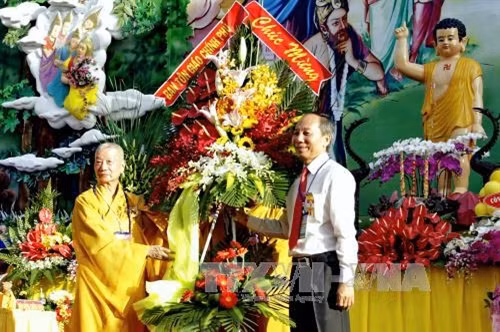 Trưởng lão Hòa thượng Thích Trí Quảng (trái), Phó Pháp chủ GHPGVN, đón nhận lẵng hoa chúc mừng từ đại diện Ban tôn giáo Chính phủ tại buổi lễ mừng Phật Đản. Ảnh: Thế Anh – TTXVN.