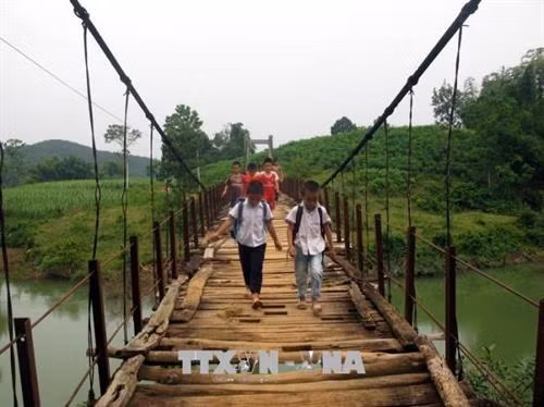 Cây cầu treo này đã xuống cấp nghiêm trọng, các dây cáp, lan can bằng sắt hoen rỉ, rệu rã, những tấm ván gỗ đã mục nát, gẫy rụng, chỉ trực chờ rơi xuống bất cứ lúc nào. Ảnh: Vũ Hà - TTXVN