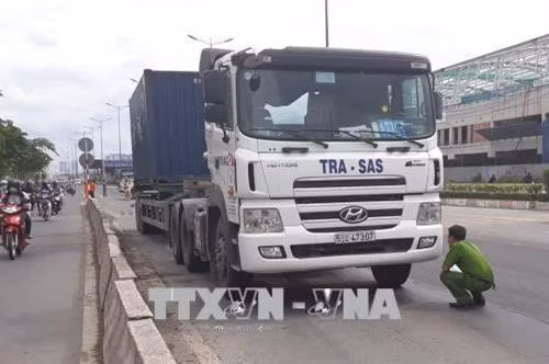 Lực lượng chức năng quận 9 khám nghiệm hiện trường trên Xa lộ Hà Nội. Ảnh: Mạnh Linh-TTXVN