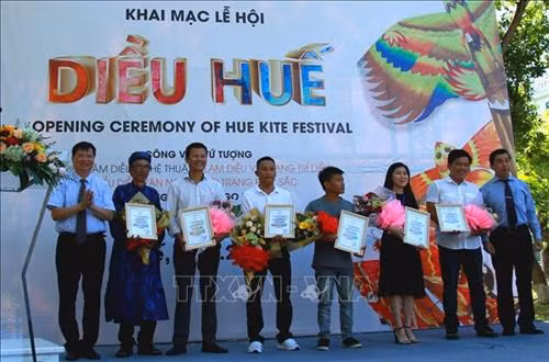 Ban tổ chức trao giấy chứng nhận cho nghệ nhân và nhà tài trợ tham gia lễ hội Diều Huế. Ảnh: Tường Vi - TTXVN