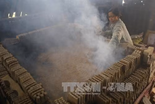 Nung sản phẩm tượng ông Công, ông Táo. Ảnh: Hồ Câu-TTXVN