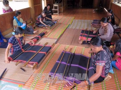 Cảnh làm việc của chị em người Cơ tu bên những khung dệt thủ công trong ngôi nhà chung của Câu lạc bộ dệt thổ cẩm thôn Agrih, xã Axan, huyện Tây Giang (Quảng Nam). Ảnh: Đỗ Văn Trưởng - TTXVN