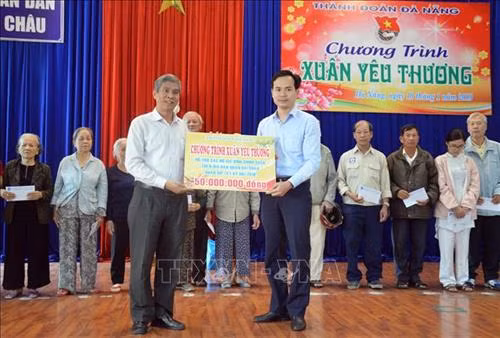 Bí thư Thành Đoàn Đà Nẵng Nguyễn Duy Minh (trái) trao biểu trưng tặng 100 suất quà cho các gia đình chính sách, hộ nghèo quận Hải Châu (Đà Nẵng). Ảnh: Đinh Văn Nhiều-TTXVN