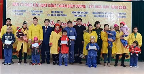 Đại diện Ban tổ chức Chương trình tặng quà cho trẻ em bị dị tật khe hở môi. Ảnh: Quang Duy - TTXVN