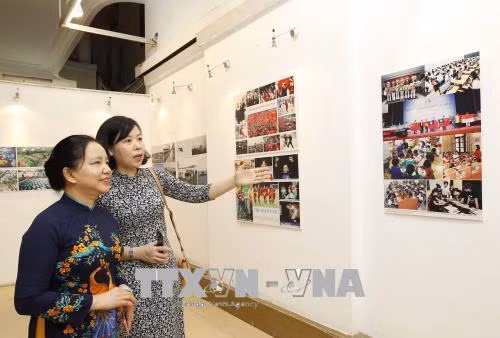 Bà Trần Thị Hà, Phó Chủ tịch thường trực Hội đồng Thi đua - Khen thưởng Trung ương, Thứ trưởng Bộ Nội vụ, Trưởng ban Ban Thi đua - Khen thưởng Trung ương và Phó Tổng giám đốc TTXVN Vũ Việt Trang tham quan triển lãm. Ảnh: TTXVN