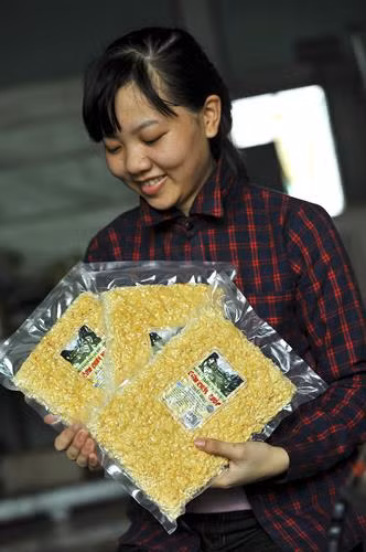 Đóng gói sản phẩm cơm cháy Ninh Bình để bảo quản tốt để xuất bán. Sản phẩm cơm cháy Ninh Bình Sau khi được nấu chín, cơm được cắt ra từng miếng nhỏ để cho vào lò sấy. Cơm được xắt thành miếng trước khi cho vào chiên giòn. Gạo được trải đều trước khi cho vào lò hấp chín.