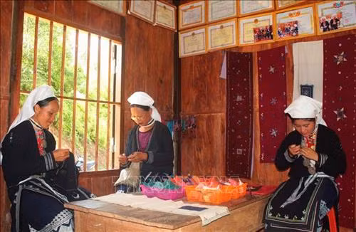 Những lúc nông nhàn phụ nữ Dao Tiền ở Nà Chắn (xã Hoa Thám, huyện Nguyên Bình) thường tập trung tại xưởng dệt để thêu thổ cẩm. Ảnh: Chu Hiệu - TTXVN