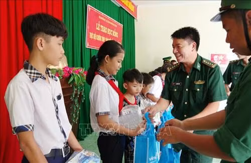 Lãnh đạo Bộ đội Biên phòng Sóc Trăng trao quà, học bổng cho học sinh dân tộc vùng ven biển. Ảnh: Trung Hiếu - TTXVN