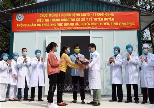 Vợ con bệnh nhân V tặng hoa cảm ơn các bác sĩ đã trực tiếp chữa bệnh cho gia đình mình. Ảnh: Hoàng Hùng - TTXVN