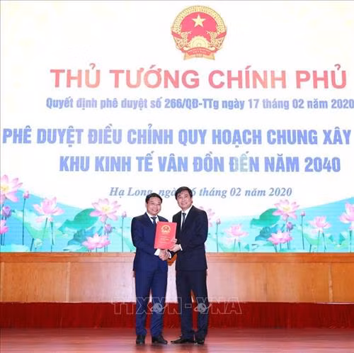 Thứ trưởng Bộ Xây dựng Nguyễn Tường Văn trao Quyết định phê duyệt điều chỉnh Quy hoạch chung xây dựng Khu kinh tế Vân Đồn đến năm 2040 cho tỉnh Quảng Ninh. Ảnh: Văn Đức - TTXVN