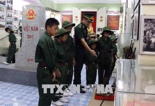 Các em học sinh tham quan nhà trưng bày, tìm hiểu về truyền thống Bộ đội Biên phòng tỉnh Sơn La. Ảnh: Diệp Anh - TTXVN