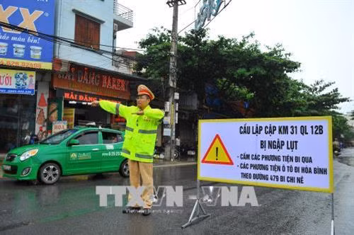Cầu Lập Cập đang được thi công trên tuyến QL12B đoạn giáp ranh giữa tỉnh Hòa Bình và Ninh Bình bị ngập sâu nên lực lượng chức năng đã cấm xe, phân luồng giao thông đảm bảo an toàn. Ảnh: Minh Đức - TTXVN