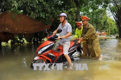 CSGT huyện Nho Quan đẩy xe giúp dân qua vùng nước ngập. Ảnh: Minh Đức - TTXVN