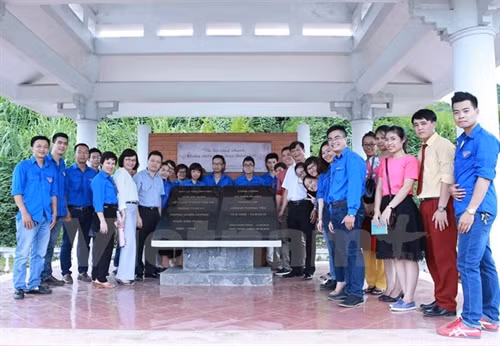 Đoàn hành trình "Về nguồn" chụp ảnh kỷ niệm tại khu nhà bia lưu niệm, nơi làm việc của Việt Nam Thông tấn xã ở An toàn khu Sơn Dương, Tuyên Quang. Ảnh: Minh Sơn/Vietnam+
