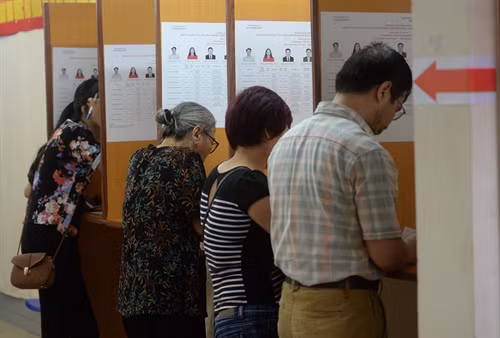 Cử tri Việt Nam điền phiếu bầu tại một điểm bầu cử ở thủ đô Hà Nội ngày 22/5. AFP/TTXVN