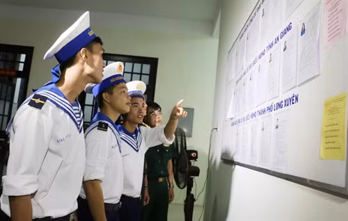 Các chiến sỹ hải quân ở thành phố Long Xuyên (An Giang) nghiên cứu tiểu sử các ứng cử viên trước khi bỏ phiếu. Ảnh: Công Mạo – TTXVN