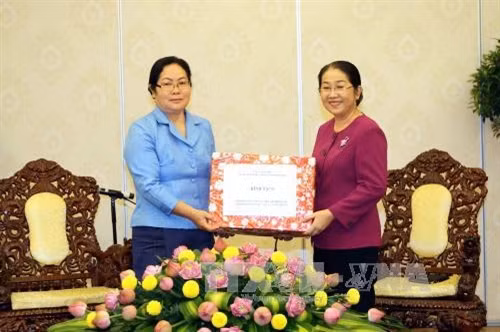 Phó Bí thư Thành ủy Thành phố Hồ Chí Minh Nguyễn Thị Dung tặng quà Phó Bí thư Thường trực Tỉnh ủy Xiêng Khoảng U-thên Ma-xi-xôn-xay. Ảnh: Thanh Vũ-TTXVN