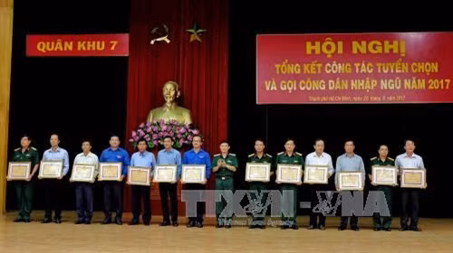 Các cá nhân tiêu biểu làm tốt công tác tuyển chọn và kêu gọi công dân nhập ngũ năm 2017 đón nhận Bằng khen của Bộ Tư lệnh Quân Khu 7. Ảnh: Thế Anh-TTXVN