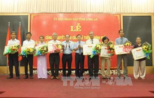 Phó chủ tịch UBND tỉnh Long An Lê Tấn Dũng trao bằng Tổ quốc ghi công cho thân nhân các gia đình liệt sĩ. Ảnh: Trường Giang – TTXVN.