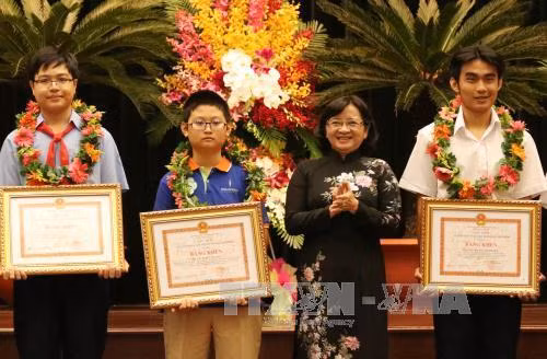 Bà Thân Thị Thư, Trưởng ban Tuyên giáo Thành ủy Thành phố Hồ Chí Minh trao Bằng khen cho các học sinh giỏi năm học 2016 - 2017. Ảnh: Phương Vy - TTXVN