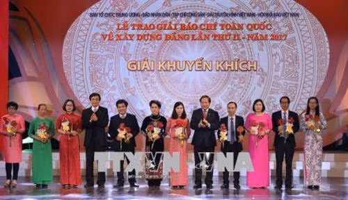 Đồng chí Trương Minh Tuấn, Bộ trưởng Bộ Thông tin và Truyền thông trao giải Khuyến khích cho các tác giải đoạt giải. Ảnh: Phương Hoa - TTXVN