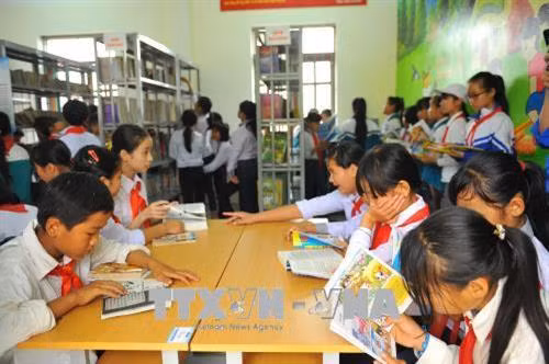 Các em học sinh Trường THCS Cúc Phương đọc sách do TTXVN trao tặng. Ảnh: Minh Đức - TTXVN