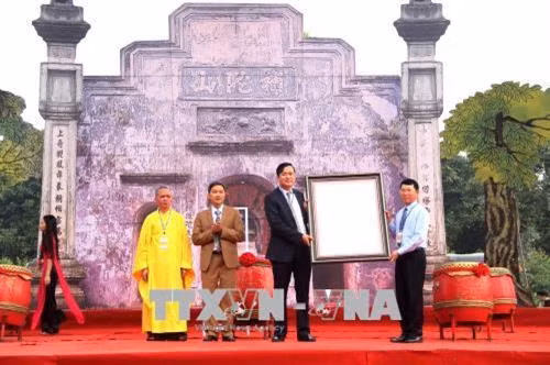 Thừa uỷ quyền của Thủ tướng Chính phủ, ông Lê Ánh Dương, Phó Chủ tịch UBND tỉnh Bắc Giang trao Quyết định của Thủ tướng Chính phủ công nhận Mộc bản kinh Phật chùa Bổ Đà là Bảo vật quốc gia cho lãnh đạo huyện Việt Yên. Ảnh: Tùng Lâm – TTXVN